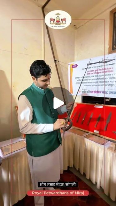 Examining a historic weapon at the Om Samrat Mandal exhibition