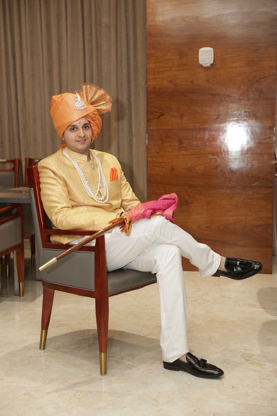 Seated in a gold sherwani and pheta