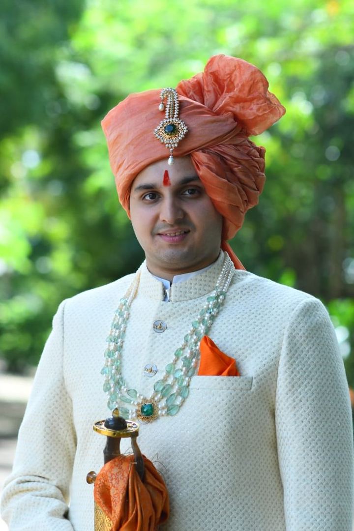 In an ivory sherwani with a peach pheta